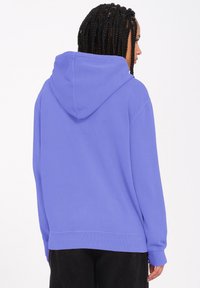 Paarse hoodie met een relaxte pasvorm, geribde manchetten en zoom. Soepele textuur zonder zichtbare patronen of accenten.