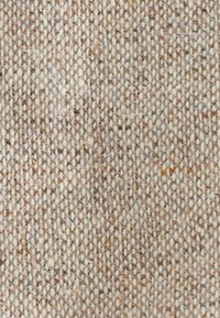 Woven fabric featuring a textured design with a neutral color palette of beige and tan, showing varying thread thickness and subtle patterns.