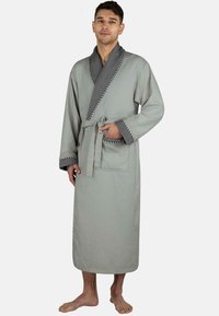 Helles graues Waffelbadekleid mit texturierter Oberfläche, kontrastierendem dunkelgrauen Kragen und Gürtel. Verfügt über eine Vordertasche und lange Ärmel.