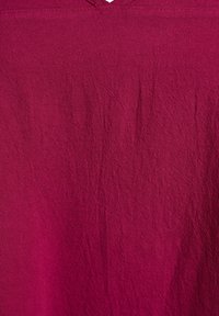 Burgundska tkanina z gubanim teksturo. Tkanina ima mehki, lahki videz z nežnim sijajem.