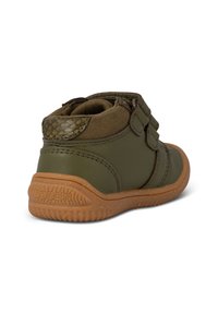 Scarpe in pelle verde con un'area in suede texturizzata e due strappi in Velcro, dotate di una suola in gomma marrone con un battistrada decorato.
