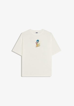 Fehér rövid ujjú póló kis Sonic the Hedgehog grafikával és sárga "Sonic Speed" felirattal a mellrészen.