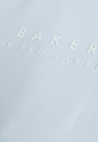Helles blaues Gewebe mit eingeprägtem weißen Text: "BAKERY by TED BAKER." Glatte Textur, subtiler Glanz, schlichtes Design.