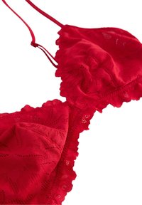 Rød blonde-bralette med blomsterprint, bølgede kanter og justerbare stropper, lavet af blødt stof med detaljeret design.