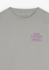 Lichtgrijze katoenen t-shirt met een ronde hals en een paarse bedrukte logo op de borst. Soepele textuur, casual pasvorm.