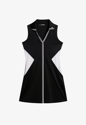 Sort ærmeløs kjole med hvide og sorte trekantede farveblokke. Har en V-hals og hvide accentstriber langs knapstolpen.