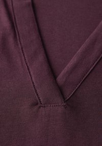 V-Ausschnitt-Pullover in tiefburgunder mit glatter Textur, präzisen Nähten und weichem, dehnbarem Stoff für optimalen Tragekomfort.