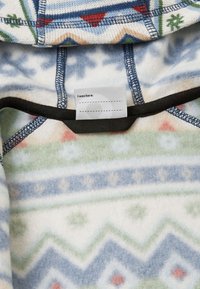 Hoodie de fleece com um padrão geométrico em branco, azul, verde e vermelho. Apresenta um rótulo preto no interior do colarinho. Textura suave, design de pullover.