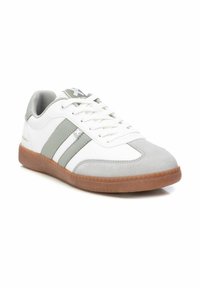 Zapatilla blanca con acentos de ante gris y dos líneas grises. Cuenta con una suela de goma texturizada y una lengua de malla acolchada para mayor comodidad.