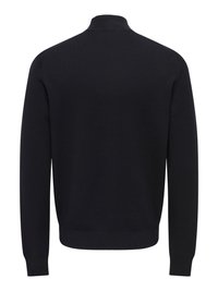 Maglione nero con collo alto, maniche lunghe e tessuto a maglia liscia. Presenta orlo e polsini a coste, con un design minimalista.
