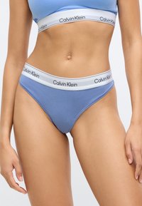Ανοιχτό μπλε βαμβακερό εσώρουχο hipster με λευκή ζώνη μέσης που φέρει μαύρη επωνυμία «Calvin Klein». Λείο υφή και μινιμαλιστικός σχεδιασμός.