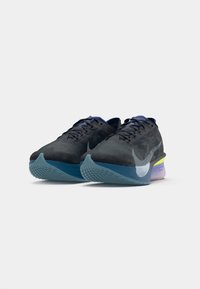 Sorte og blå Nike løbesko med gule og lilla detaljer, vinklede for at vise front- og sidebesigtigelser på en hvid baggrund.