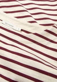 Bordeaux-rot und creme gestreiftes T-Shirt aus weichem Stoff, mit Rundhalsausschnitt und sichtbaren Nähten. Das Etikett zeigt die Marke "hessnatur", Größe 36.