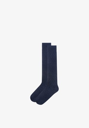Paar marineblaue knielange Socken mit kleinen weißen Punkten, gleichmäßig über den Stoff verteilt.