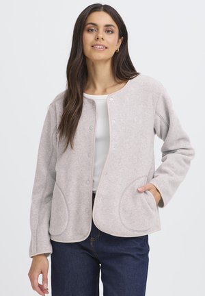 Világosszürke, texturált polárdzseki kerek nyakkivágással, patentgombokkal és ívelt első zsebekkel; kontrasztos szegélyekkel kivitelezve.