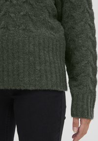Dunkelgrüner Strickpullover mit geripptem Saum und strukturiertem Zopfmuster am Körper und an den Ärmeln. Weiches, fusseliges Material.