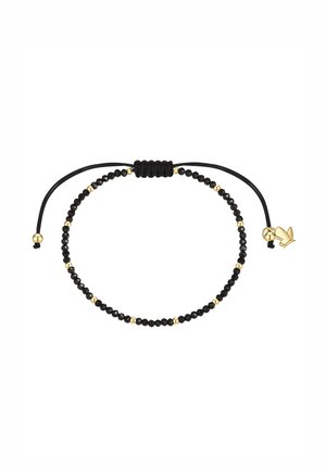 Regulowana czarna bransoletka z koralikami z małymi złotymi koralikami oraz złotym zawieszonym ptakiem na regulowanych czarnych zakończeniach sznurka.