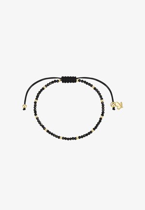 Bracelet noir ajustable avec perles, petites perles dorées et un charm oiseau doré aux extrémités réglables du cordon noir.