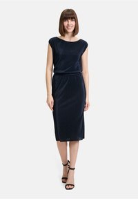 Marineblauwe knielange jurk van ribbelstof, met een bateauhals en korte mouwen, cincht op de taille met een elastische band.