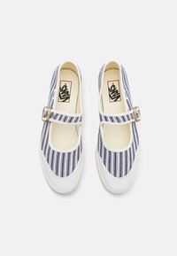 Chaussures en toile rayées bleu marine et blanches avec un bout rond, une sangle à boucle et une semelle en caoutchouc blanc. Présente un logo Vans minimaliste à l'intérieur.