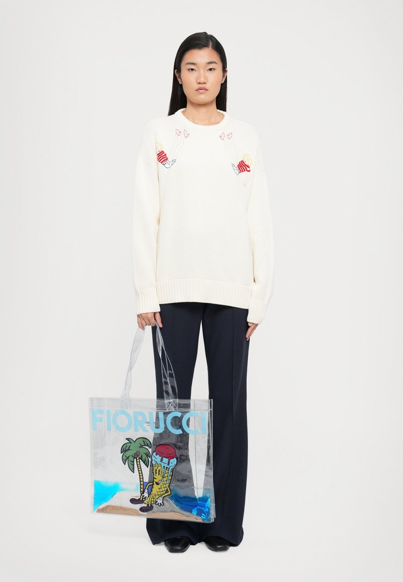 Priehľadná taška s farebným kresleným dizajnom, modrým textom "FIORUCCI", palmami a postavou na pieskovom podklade s modrými akcentmi.