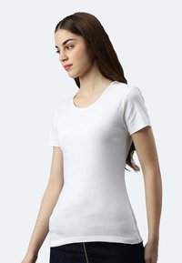 T-shirt bianca a maniche corte realizzata in morbido tessuto, con scollatura rotonda e design aderente, adatta per un abbigliamento casual.