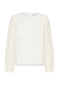 Haut blanc avec un col rond et des manches longues en dentelle brodée transparente. Le corps en tissu lisse contraste avec le motif floral texturé des manches.