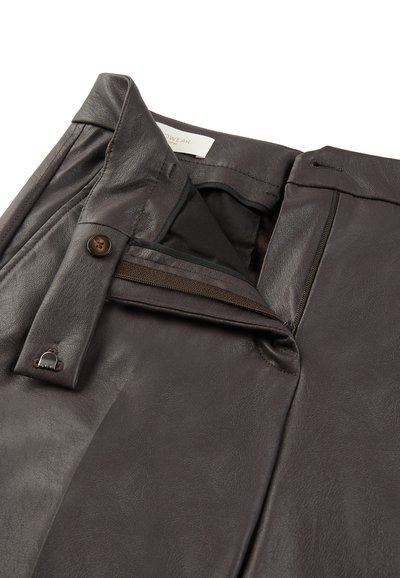 Ciemnobrązowe skórzane spodnie o gładkiej fakturze, z zamkiem błyskawicznym i zapięciem na guzik, z widoczną podszewką w okolicach pasa.