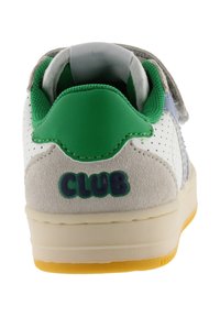 Witte sneaker met groene accenten, een grijze suède hiel en geperforeerde panelen. Op de achterkant staat het woord "CLUB" in groen. Rubberen zool.
