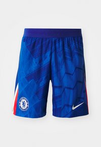 Blauwe voetbalshorts met een geometrisch patroon, voorzien van een paarse tailleband. Inclusief een Chelsea FC-logo en een witte Nike-swoosh.