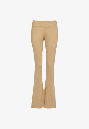 Beige joogapüksid laia elastse vöökohaga, valmistatud pehmest kangast, vasakul puusal väike valge logo.