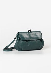 Clutch bag in pelle verde con patta pieghevole, chiusura tonda e tracolla regolabile. La texture liscia e la forma arrotondata ne esaltano il design.