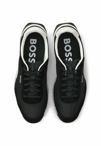 Black sneakers featuring a mix of textured fabric and suede, white accents, round toe design, and branded insoles with "BOSS" logo.