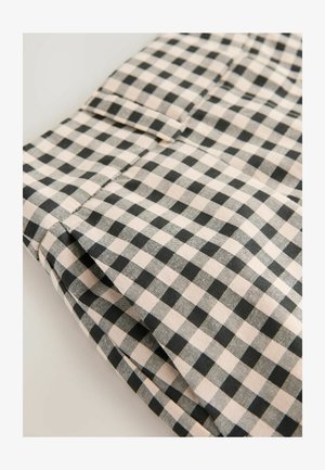 Mustreeritud musta ja beeži kontrolliga kangas, millel on sile tekstuur. Üksikasjades on näha volditud osa koos tasku ja puhta viimistlusega õmblusjoontega.