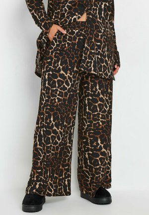 Twee-delig outfit met luipaardprint, bestaande uit een lange button-up shirt en wijde broek in zwart, bruin en crème tinten, gemaakt van een zachte stof.