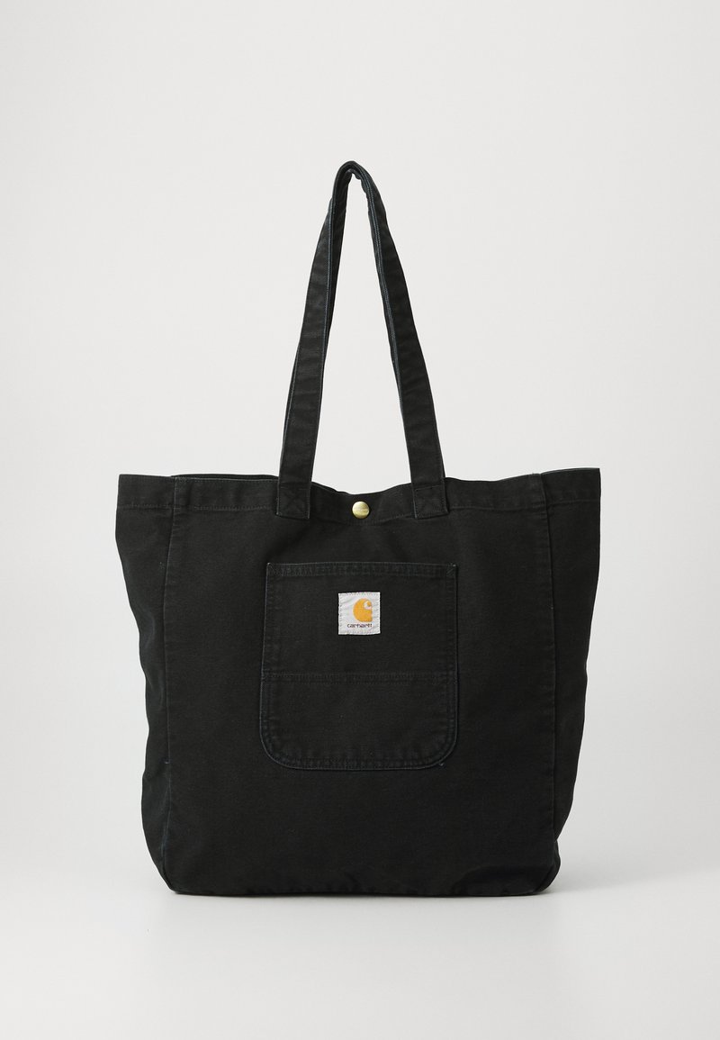 Borsa a spalla nera in tela con due manici resistenti, una tasca frontale e un piccolo patch con logo. Presenta una chiusura a pulsante nella parte superiore.