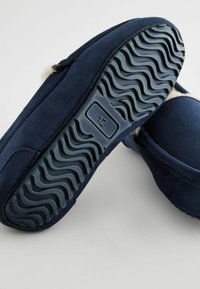 Morské modré semišové papuče s mäkkou podšívkou, plochá gumová podrážka s vlnovým vzorom pre lepšie grip, veľkostná etiketa na podrážke.