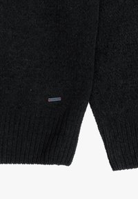 Maglia nera a maglia con texture a coste, dotata di un piccolo etichetta con marchio. Il design ha una forma classica e una finitura testurizzata.