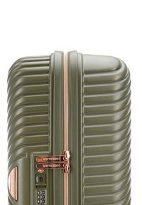 Valigia rigida verde oliva con texture a righe, zipper oro rosa e lucchetto a combinazione. Presenta il marchio WITTCHEN sull'hardware.