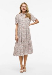 Kwiatowa sukienka z kołnierzykiem, krótkimi rękawami i falbaniastą spódnicą. Posiada białe tło z małymi czerwonymi i niebieskimi kwiatkami. Gładki materiał.