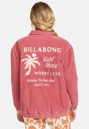 Roze corduroy jas met een relaxte pasvorm, voorzien van witte geborduurde tekst en een palmboomontwerp op de achterkant. Ribgebreide kraag en manchetten.