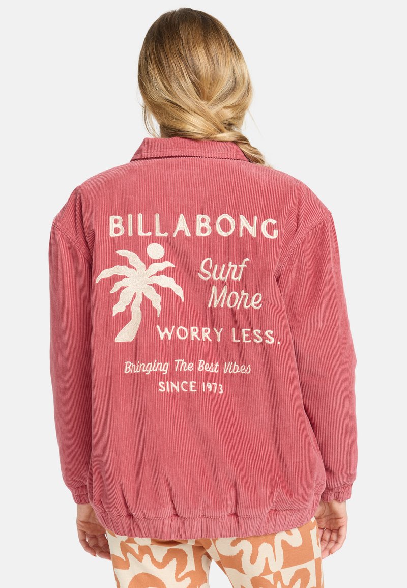 Giacca in corduroy rosa con una vestibilità rilassata, caratterizzata da testo ricamato bianco e design di palme sul retro. Colletto e polsini a coste.
