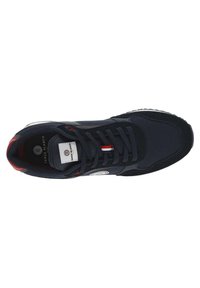 Marineblauwe sneaker met een bovenwerk van textiel, ronde neus en gevoerde kraag. Heeft een witte zool en rood, wit en blauwe accenten op de tong.