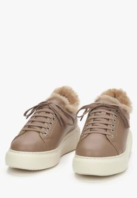 Bruine leren sneakers met een pluche bontvoering, voorzien van een ronde neus, een vlakke witte zool en vetersluiting met metalen oogjes.