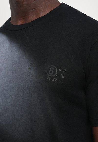 Svart bomull t-shirt med rund halsringning, kort ärm och en diskret tryck med siffror samt siffran "6" på bröstet.