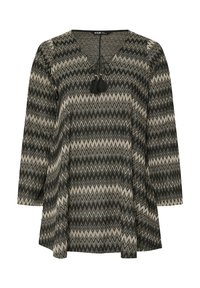 Zwarte en beige geblokte tuniek met een v-hals, lange mouwen, trekkoord bij de hals en franjes. Heeft een zigzagpatroon en een vloeiende vorm.