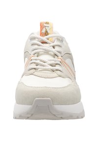 Baskets blanches et beiges avec une semelle épaisse, des lacets blancs, des surpiqûres orange et une languette à motif orange-jaune avec un logo blanc.
