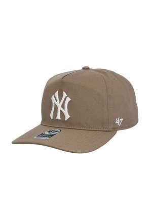Beige baseball cap with white embroidered "NY" logo on front and "47" logo on side, featuring a curved brim and adjustable strap.