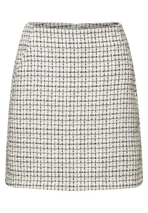 A-lijn rok in een gestructureerde, wit en zwart geweven stof met een ruitpatroon. Heeft een naadloze taille en een verborgen ritssluiting aan de achterkant.