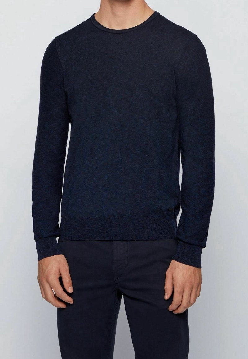 Námořnická modrá mikina s dlouhým rukávem a kulatým výstřihem, vyrobená z texturované tkaniny, s žebrovanými manžetami a pasem, doplněná jemným melírováním.